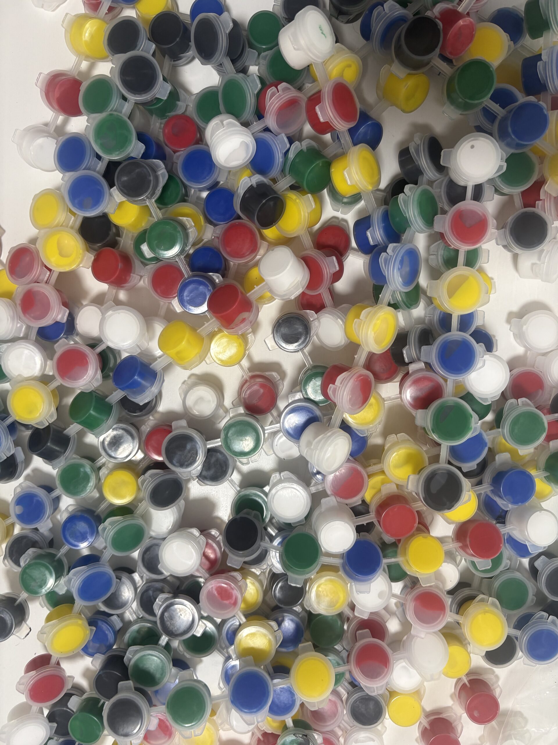 Colorful assortment of plastic bottle caps in red, blue, yellow, green, white, and black scattered together